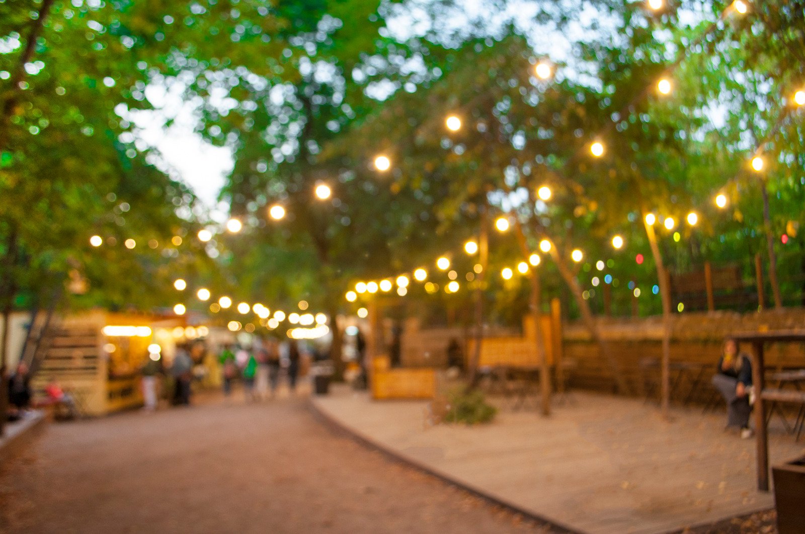 Outdoor community event with warm string lights at dusk